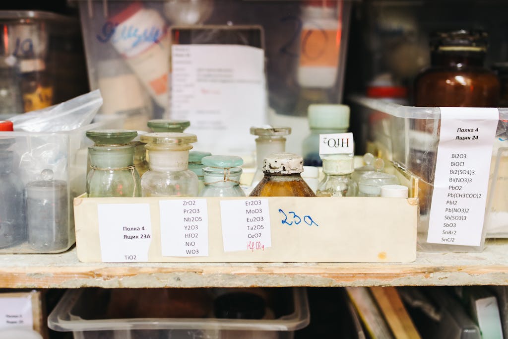 A collection of various chemical samples in glass jars, stored in a laboratory setting.